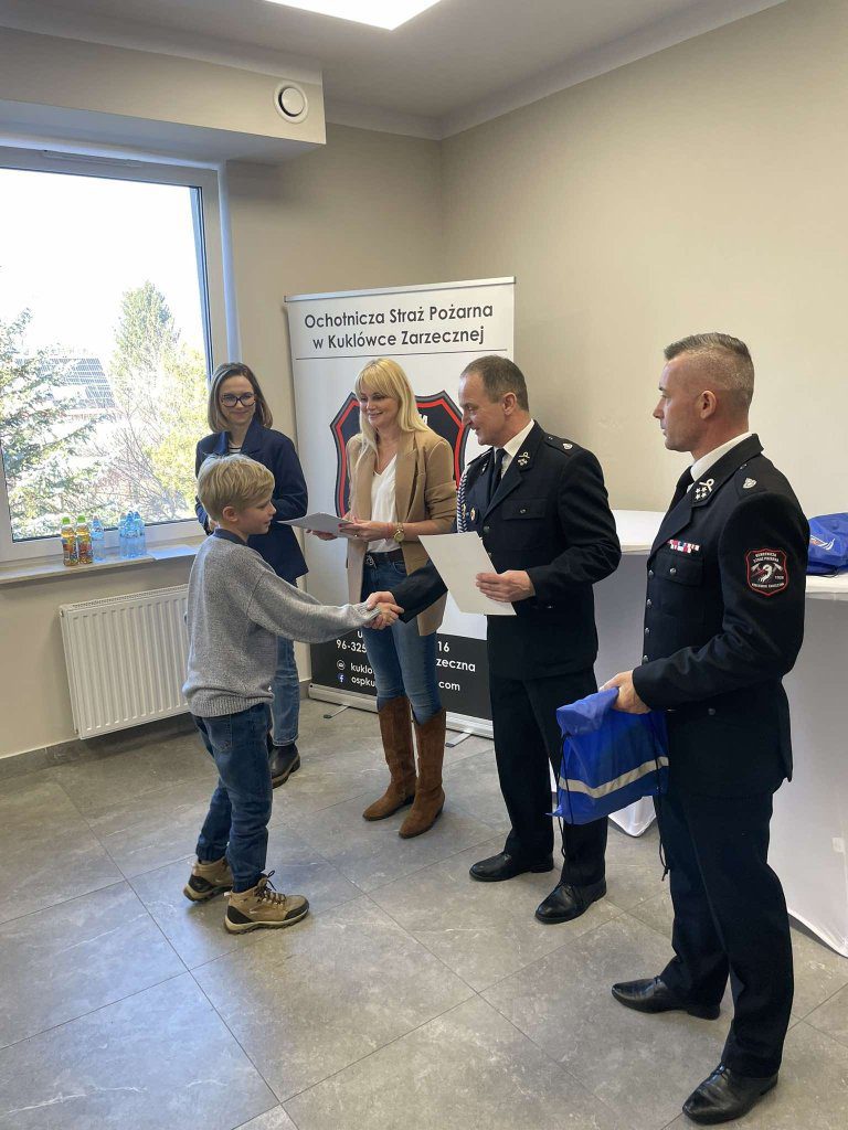 Osoby wręczają nagrody i dyplomy