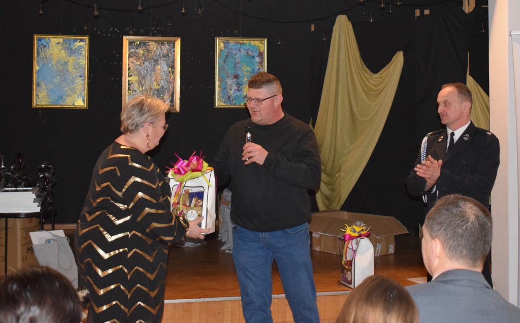 Prezesi wręczający słodki upominek Przewodniczącej Rady