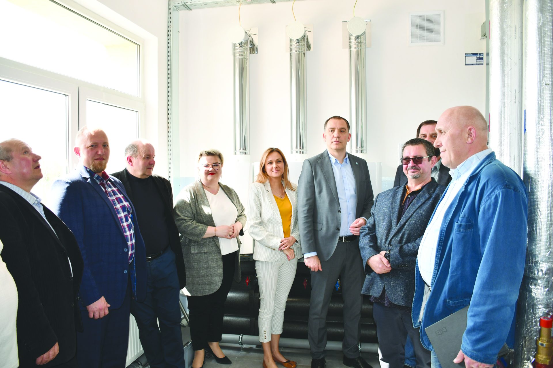 Przedstawiciele władz stojący na tle kotłowni