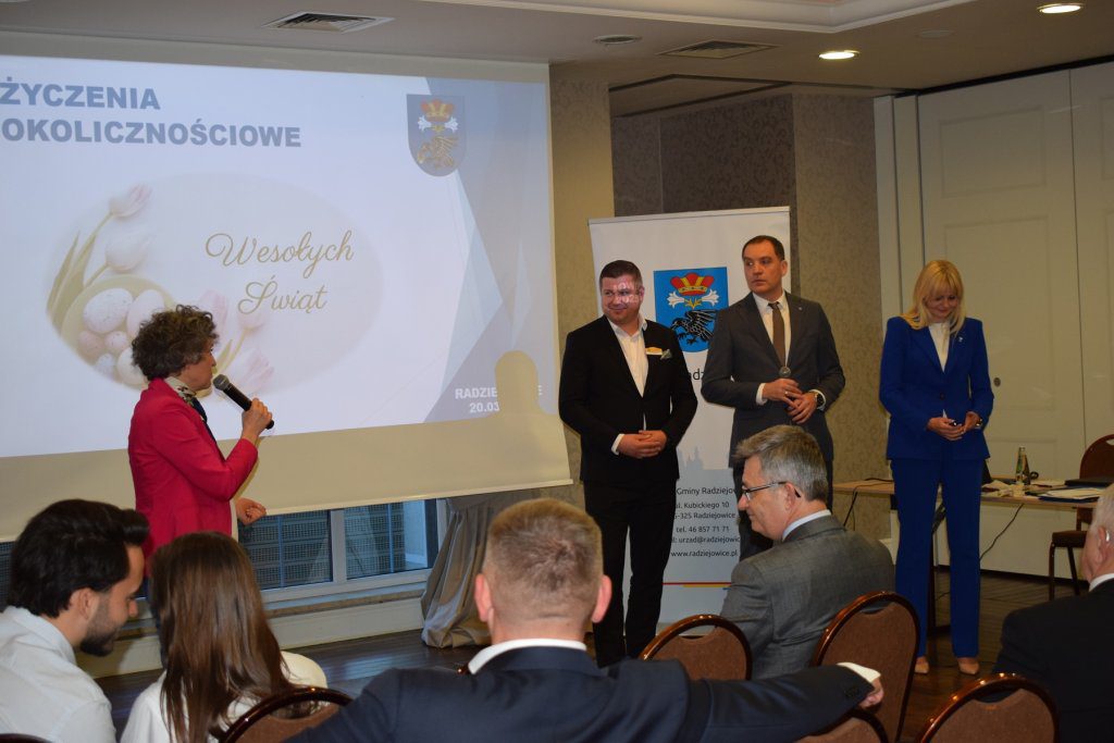 Cztery osoby. Kobieta przemawia.