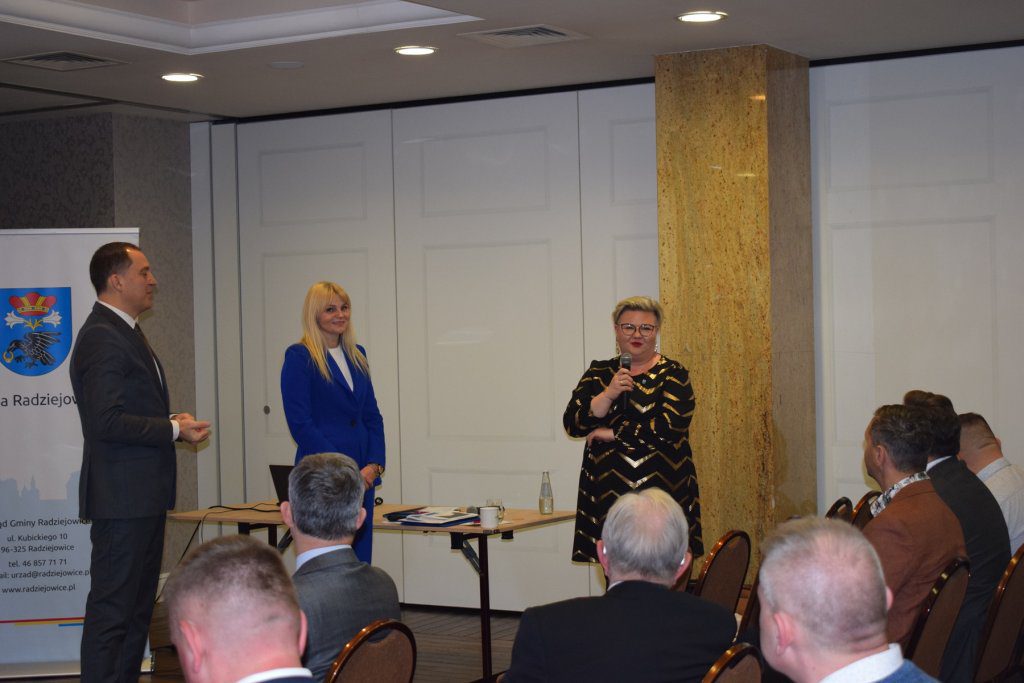 Trzy osoby. Kobieta przemawia.