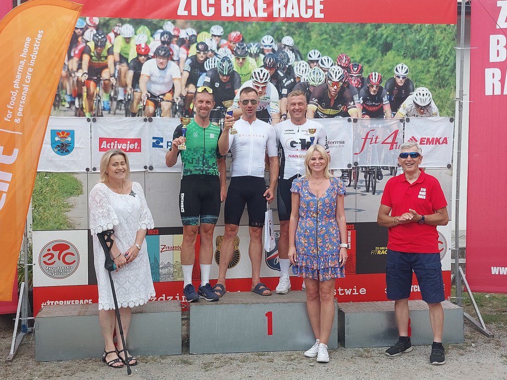 Zwycięzcy wyścigu na podium z okolicznościowymi pucharami