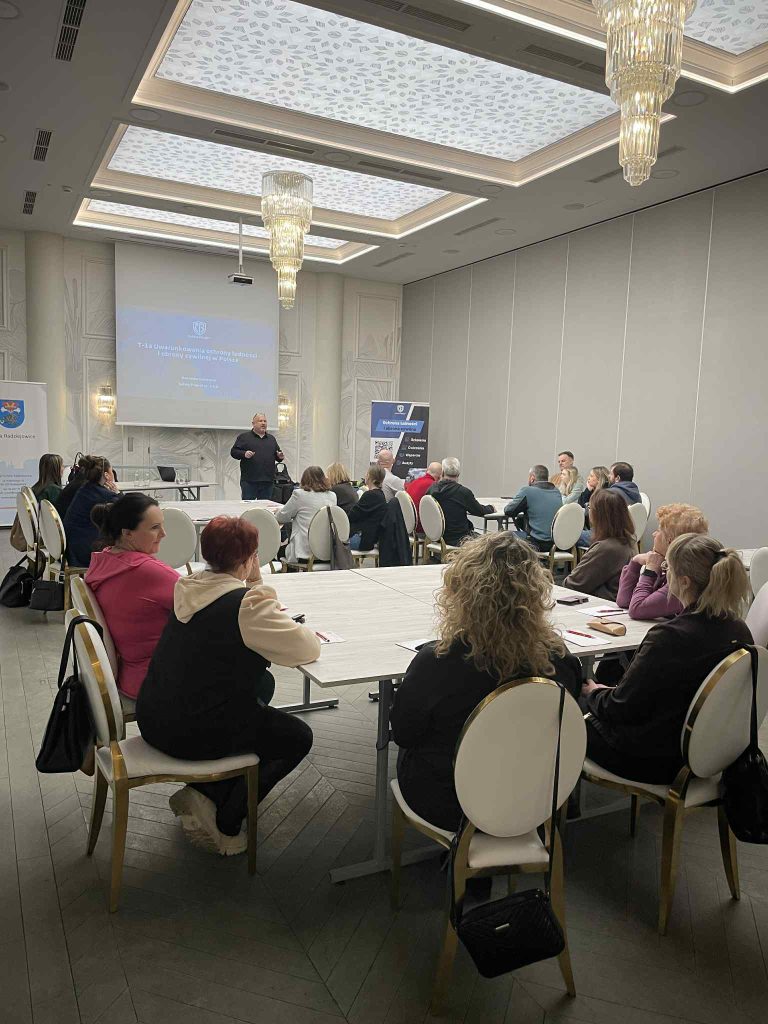 Uczestnicy szkolenia siedzą w sali konferencyjnej i słuchają prezentacji...