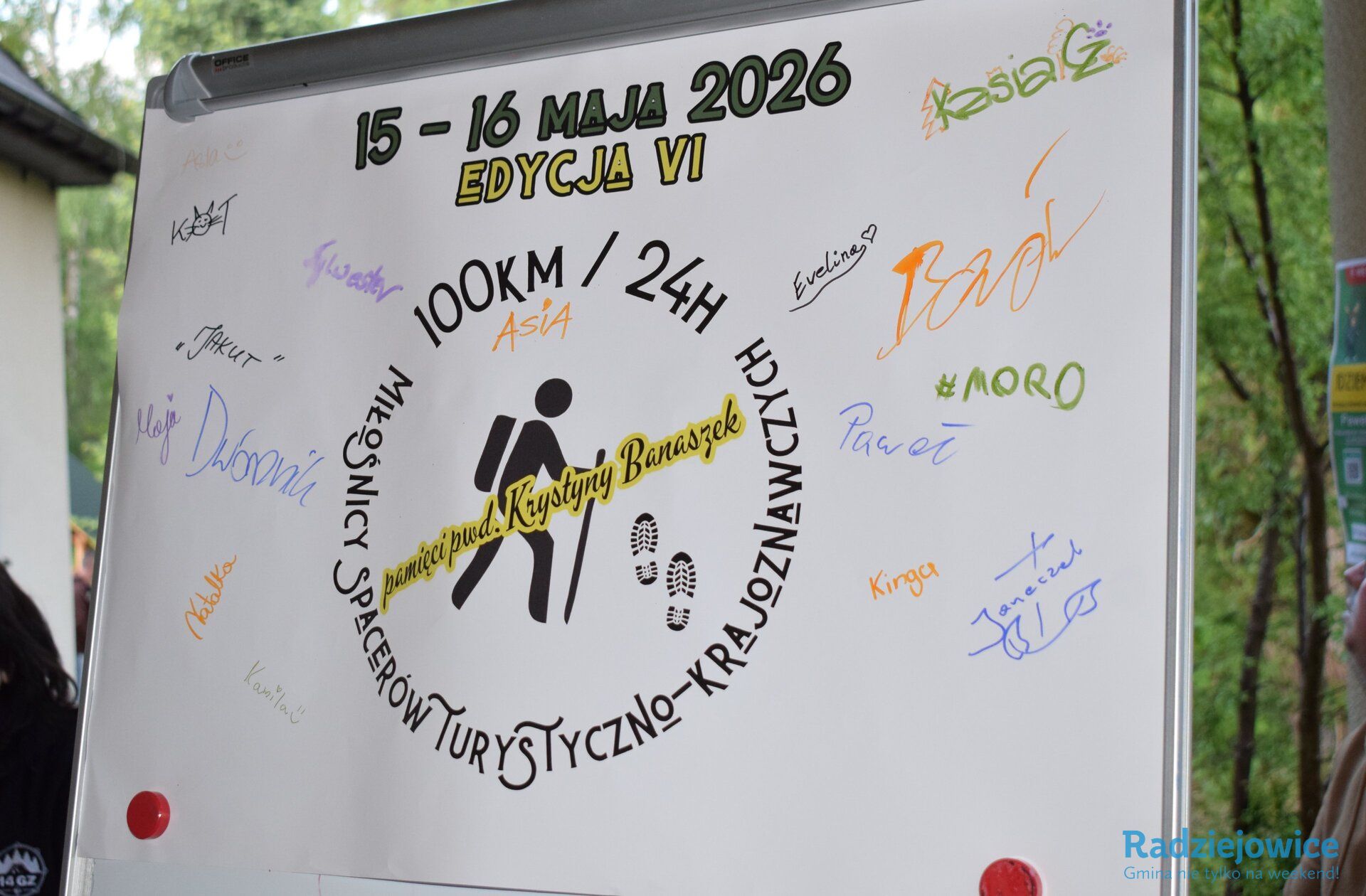 Tablica z logo VI edycji Marszu 100 km w 24 h pamięci pwd. Krystyny Banaszek, datą wydarzenia „15–16 maja 2026” oraz podpisami i wpisami pozostawionymi przez uczestników wydarzenia