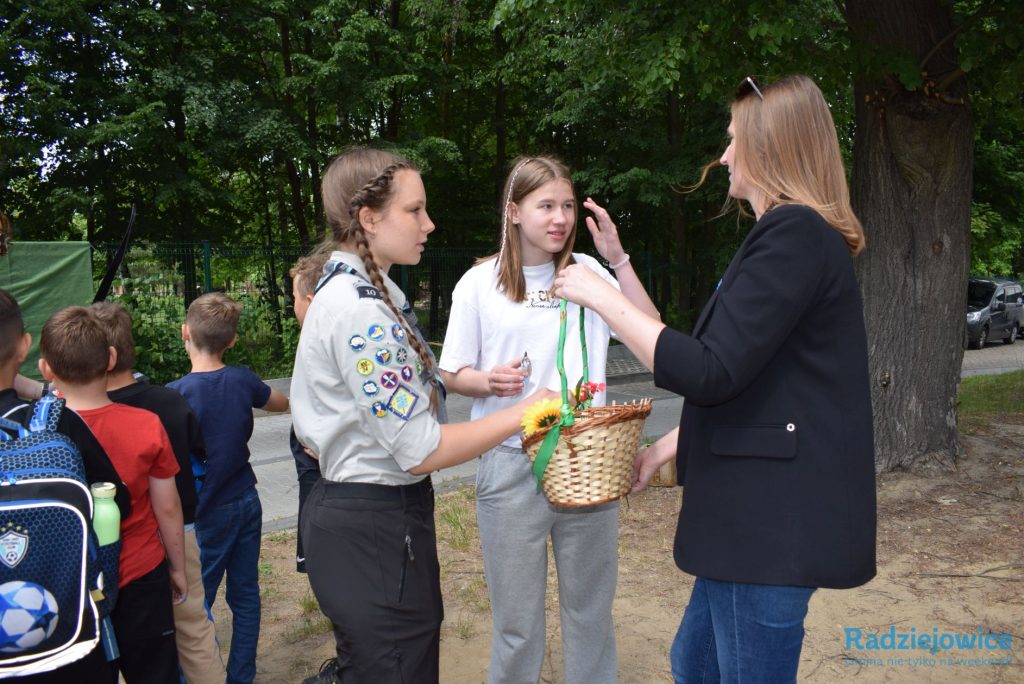Dyrektorka Gminnego Cenrtum Oświaty rozmawia z młodzieżą i wręcza upominki podczas spotkania z okazji Dnia Dziecka na terenie szkoły.