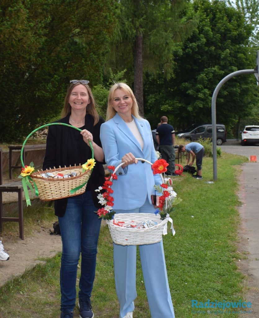 Zastepca Wójta i Dyrektor Gminnego Centrum Oświaty prezentują kosze ze słodyczami przygotowanymi dla dzieci uczestniczących w obchodach Dnia Dziecka.