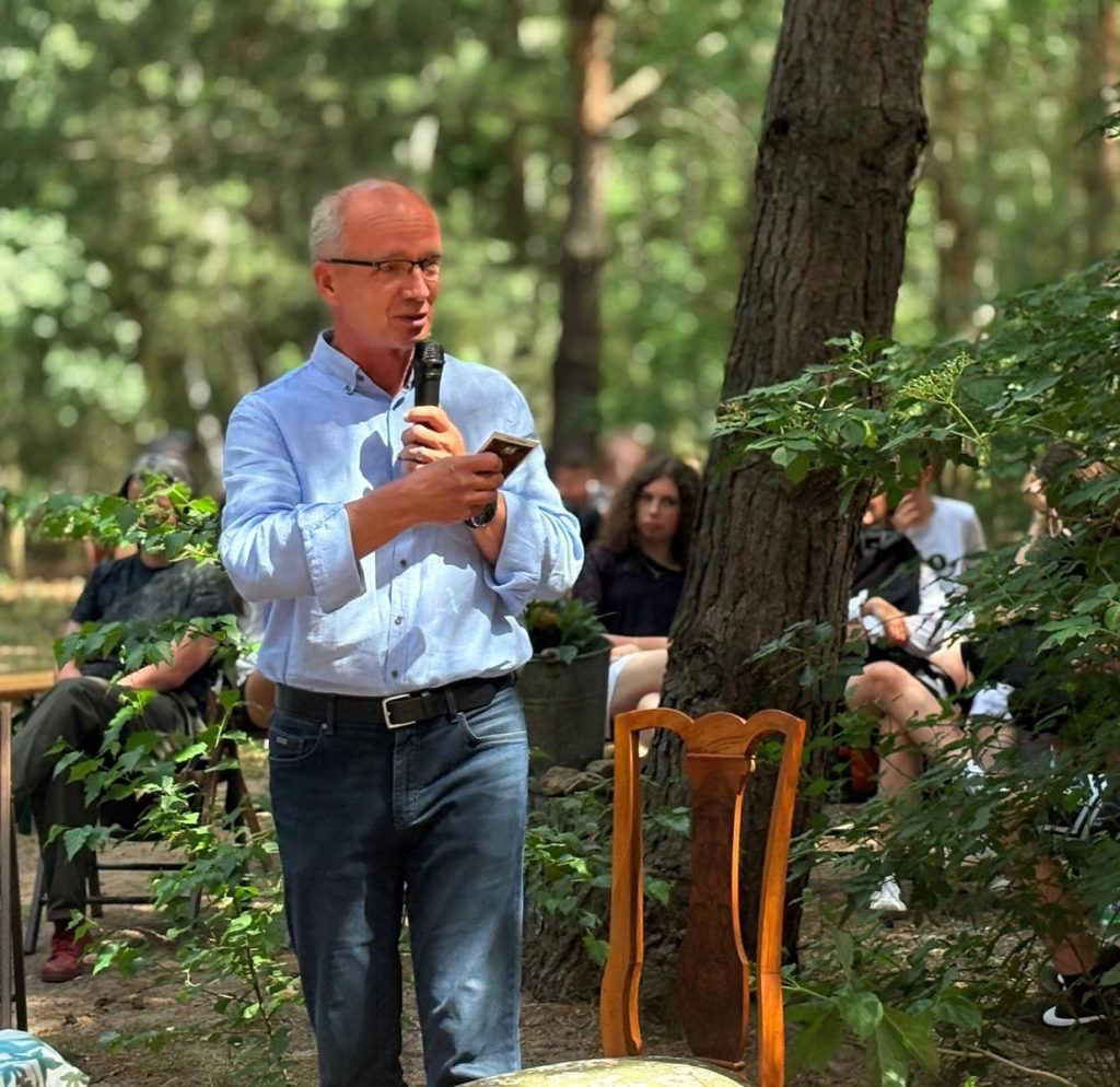 Krzysztof Szwagrzyk, Wiceprezes Instytutu Pamięci Narodowej, wygłasza prelekcję podczas wydarzenia „Świadkowie Historii”. W tle znajdują się uczestnicy spotkania.