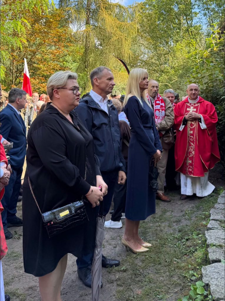 Uczestnicy uroczystości stoją tablicą pamiątkową. Wśród nich znajdują się przedstawiciele władz, duchowieństwa oraz formacji patriotycznych.