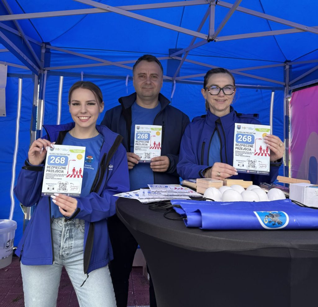 Przedstawiciele Gminy Radziejowice prezentują ulotki promujące projekt nr 268 „Bezpieczne przejścia” podczas wydarzenia plenerowego.