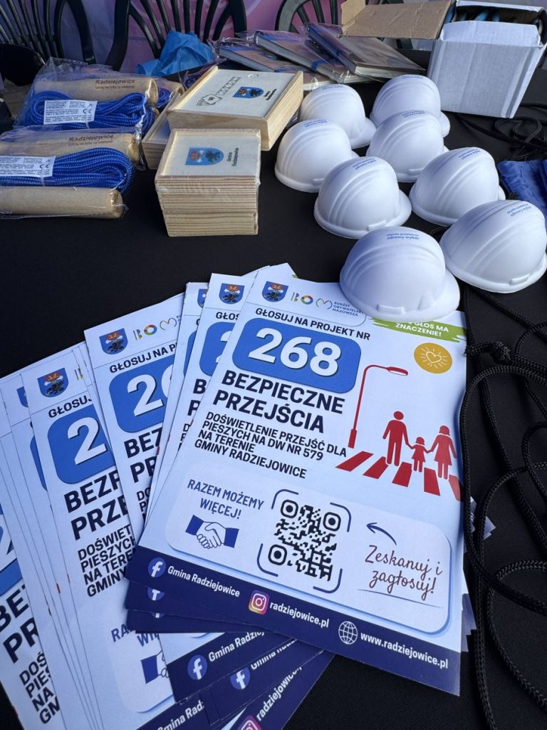 Ulotki promujące projekt nr 268 „Bezpieczne przejścia” oraz materiały promocyjne Gminy Radziejowice i kaski ochronne przygotowane na stoisku.
