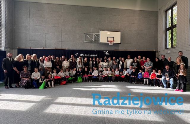 Grupa uczniów, rodziców i nauczycieli pozują do grupowego zdjęcia
