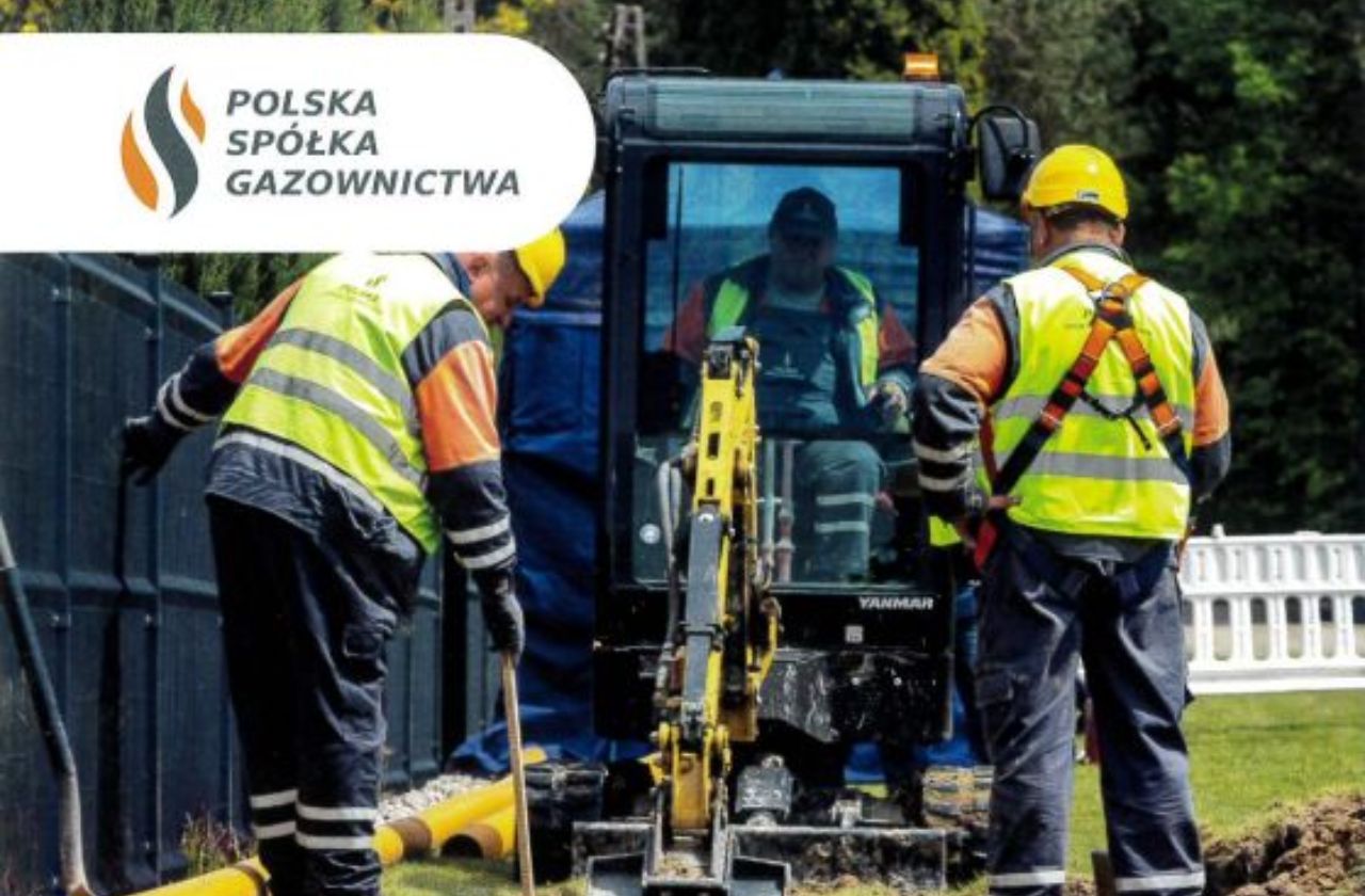 Na zdjęciu dwóch pracowników w odzieży ochronnej i żółtych kaskach prowadzi prace ziemne przy użyciu minikoparki. W tle widoczny jest pojazd oraz teren zielony. W lewym górnym rogu znajduje się logo Polskiej Spółki Gazownictwa.